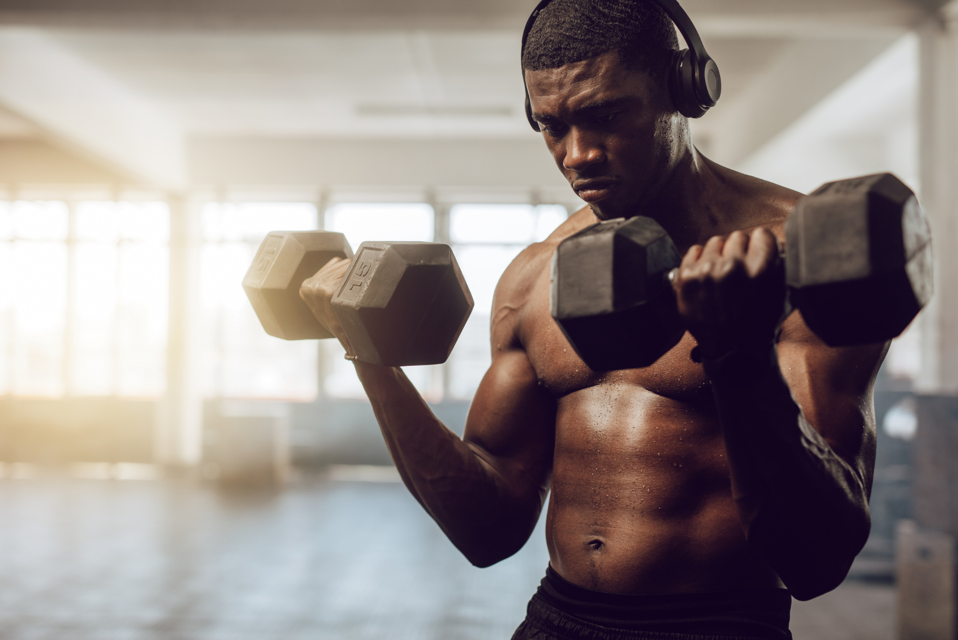 man training with lifting dumbells