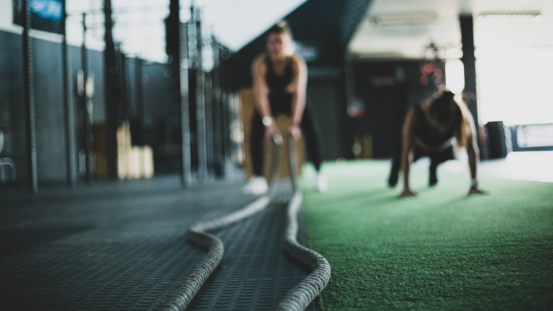 A man in a gym holding battle ropes in preparation to start exercising