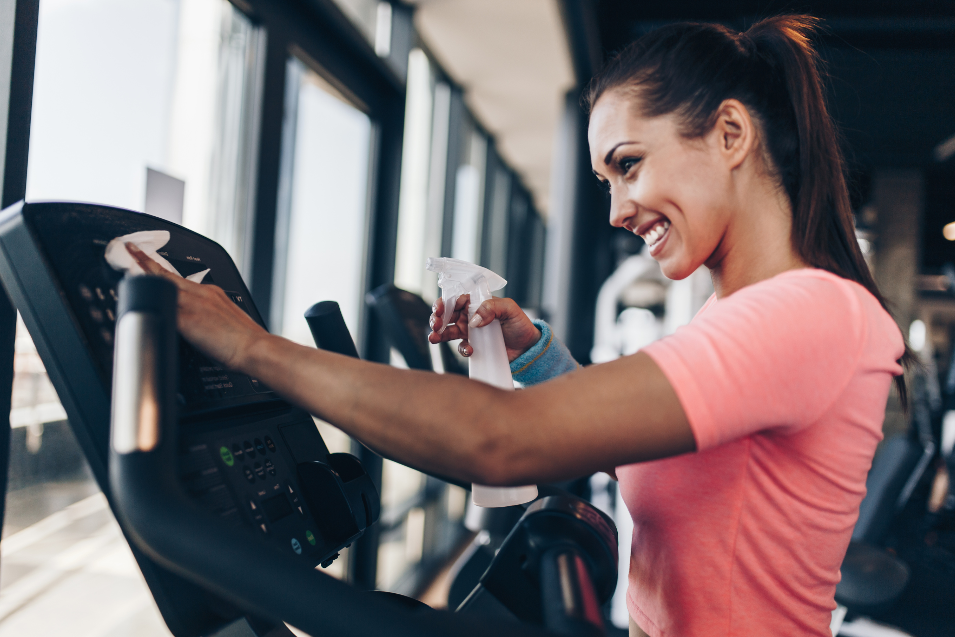 woman cleaning gym equipment