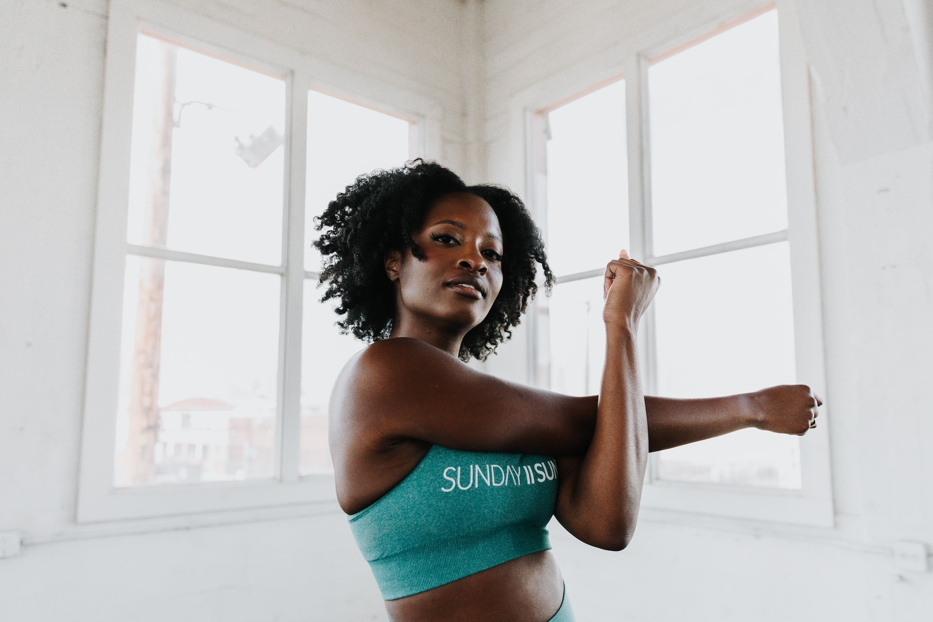 une femme en soutien-gorge de sport étirant ses bras