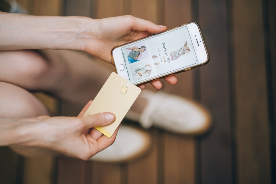 a person holding an iphone and a credit card in their hands