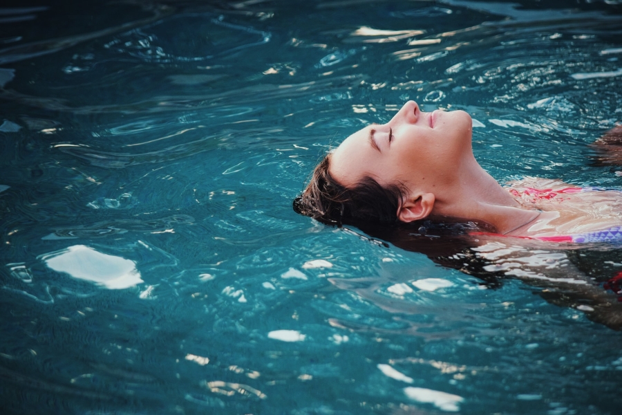 A woman relaxing floating in a swimming pool