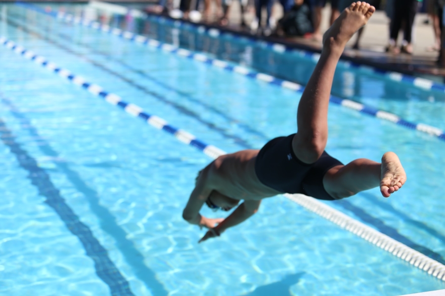 A boy jumping into a swimming pool