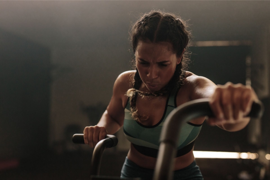 woman exercising hard on a gym bike