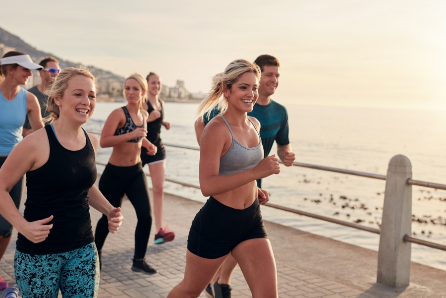 people running by the water in a sunset