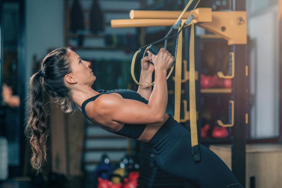 woman lifting on a ropes at the gym